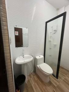 a bathroom with a white toilet and a sink at Hollywood Suites Gensan in General Santos
