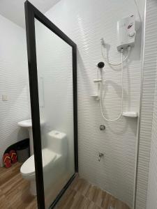 a bathroom with a shower and a toilet and a mirror at Hollywood Suites Gensan in General Santos