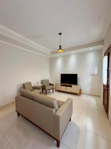 a living room with a couch and a tv at Vila dos Pinheiros 1 in Serra Negra