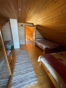 an attic room with two beds and a rug at Oksa Puhkemaja in Võru