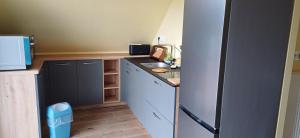 a small kitchen with a sink and a refrigerator at Logis de la Provosterie CLICRO in Ahuillé