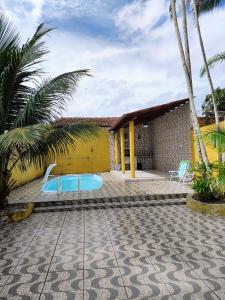 a resort with a swimming pool and two chairs at Casa em Mosqueiro com Piscina in Belém