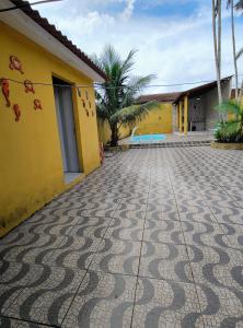 a house with a tiled driveway in front of a building at Casa em Mosqueiro com Piscina in Belém