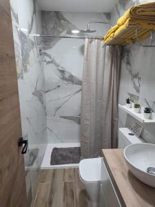 a bathroom with a shower and a toilet and a sink at Kiriki rooms in Camas