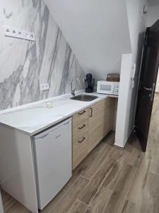 a kitchen with a sink and a microwave at Kiriki rooms in Camas