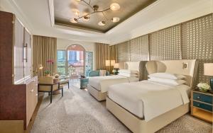 a bedroom with two beds and a living room at Emirates Palace Mandarin Oriental, Abu Dhabi in Abu Dhabi