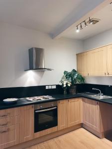 a kitchen with wooden cabinets and black counter tops at Beds at 46, Cowes in Cowes +21 photos
