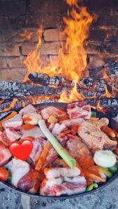 a grill with meat and vegetables with a heart on it at Vikendica Dani in Ljubovija