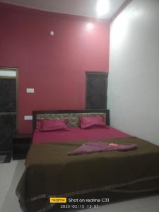 a bedroom with a large bed with pink walls at Shree krishna guest House near Ram mandir in Ayodhya +11 photos