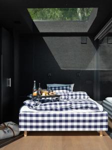 a black bedroom with a bed with a checkered blanket at Kilsti Lodge in Eidsdal