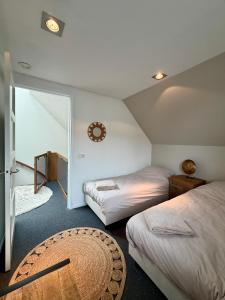 a bedroom with two beds and a mirror and a rug at Thuysgrond in Bergeijk