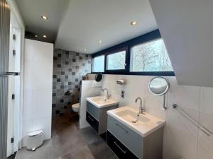 a bathroom with two sinks and a toilet at Thuysgrond in Bergeijk +12 photos