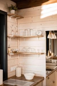 a kitchen with wooden walls and shelves with glasses at BeLaWood in Egerszalók