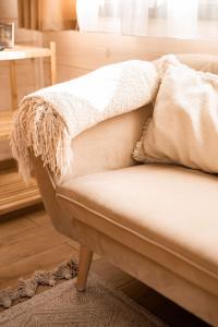 a couch with a blanket on top of it at BeLaWood in Egerszalók