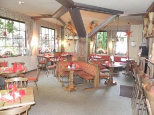 a restaurant with tables and chairs in a room at Landhotel Osterlamm in Grünhain