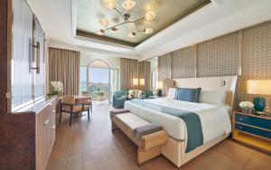 a bedroom with a large bed and a living room at Emirates Palace Mandarin Oriental, Abu Dhabi in Abu Dhabi