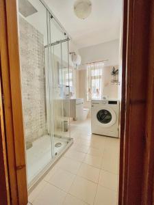 a bathroom with a shower and a washing machine at Nicole's House in Vieste