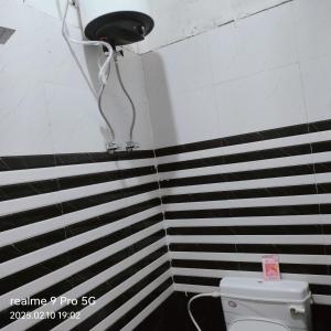 a bathroom with a toilet and black and white stripes at Shree krishna guest House near Ram mandir in Ayodhya