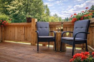 two chairs and a table on a wooden deck at Chata Škerda - Zuberec in Zuberec
