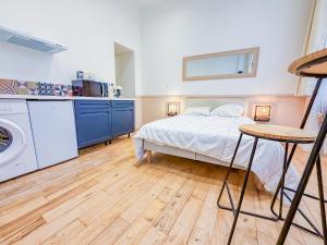 a bedroom with a bed and a washing machine at Studio Riom - Proche gare SNCF in Riom