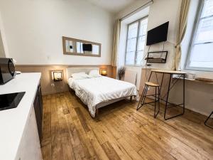 a bedroom with a bed and a desk in it at Studio Riom - Proche gare SNCF in Riom