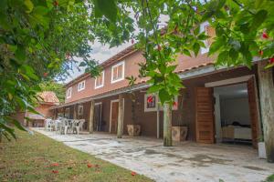 a house with a patio with tables and chairs at Pousada Campina do Monte Alegre in Campina do Monte Alegre