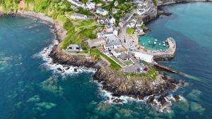 an aerial view of a house on an island in the water at The Paris Hotel in Coverack