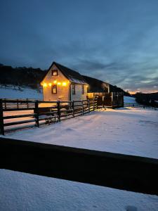 a building with lights on it in the snow at The Niblet Bonnie View Glamping Cabins, Helmsley in Carlton +14 photos