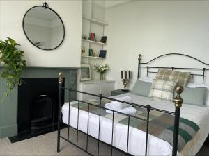 a bedroom with a bed with a mirror and a fireplace at Beds at 46, Cowes in Cowes