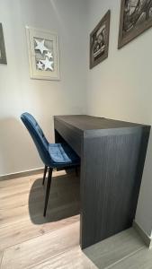 ein Schreibtisch mit einem blauen Stuhl neben einer Wand in der Unterkunft Ocean views in Plataria