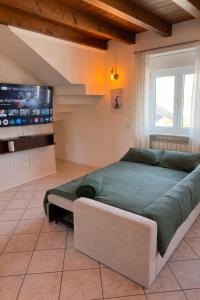 a bedroom with a large bed and a tv at Garda Green - Luxury Apartment in Lonato