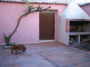 a pink building with a door and a fireplace at Casa Rural Los Boteros in Pesquera de Duero