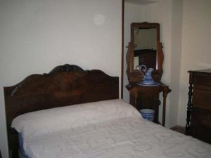 a bedroom with a bed and a mirror at Casa Rural Los Boteros in Pesquera de Duero +1 photo