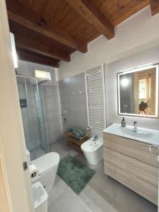 a bathroom with a tub and a sink and a toilet at Garda Green - Luxury Apartment in Lonato +34 photos
