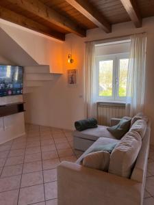 a living room with a couch and a tv at Garda Green - Luxury Apartment in Lonato