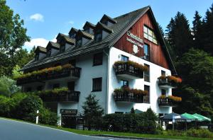 a large white building with balconies and flowers on it at Landhotel Osterlamm in Grünhain