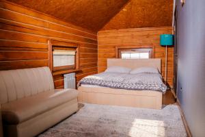 a bedroom with a bed and a chair in a cabin at KokTau in Kokshetau