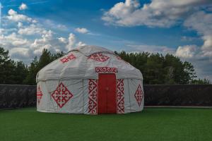 a large dome tent with a red door on a field at KokTau in Kokshetau