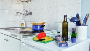 a kitchen counter with a sink and a counter top with a knife and vegetables at Apartmani Conar in Drvenik Veli