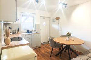 a kitchen with a table and a small kitchen with a table and chairs at Red Maple Apartments in Maribor