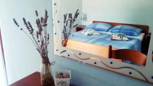 1 dormitorio con 1 cama con sábanas azules y almohadas azules en Apartmani Conar, en Veliki Drvenik