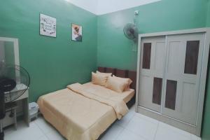 a small bedroom with a bed and a door at D 'Fidarez Homestay in Pendang