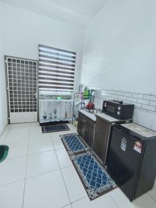 a kitchen with a stove and a refrigerator at D 'Fidarez Homestay in Pendang +5 photos