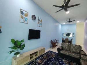 a living room with a couch and a flat screen tv at D 'Fidarez Homestay in Pendang