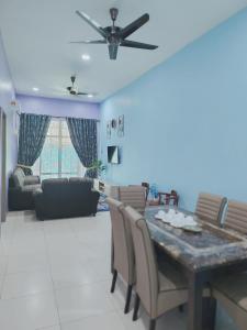 a dining room and living room with a table and chairs at D 'Fidarez Homestay in Pendang