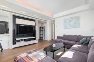 a living room with a couch and a tv at City Penthouse in Larnaca