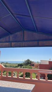 a bench sitting under a building with a blue roof at Imi Ouaddar Sea View Retreat in Agadir