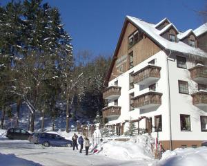 a group of people standing outside of a snow covered building at Landhotel Osterlamm in Grünhain +17 photos
