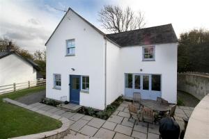 a white house with a patio and a table at 3 Bed in Gower oc-hh472 in Cheriton