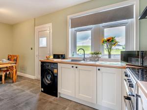 a kitchen with a washer and dryer next to a window at 2 Bed in Carluke oc-95359 in Carluke +10 photos